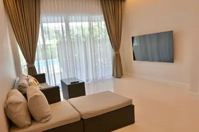 a living room with a couch and a flat screen tv at The Pelican Suite Residence Condo Klong Muang, Krabi in Klong Muang Beach