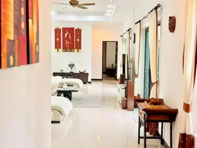 a living room with white furniture and a hallway at BlueElephant Villa NaiHarn in Rawai Beach