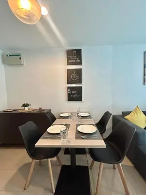 a dining room with a table and chairs and a table and chairsktop at Centrio 2 Bedrooms Condos in Town-Central Phuket in Ban Rangeng