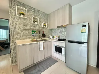 a kitchen with a refrigerator and a sink at Centrio 2 Bedrooms Condos in Town-Central Phuket in Ban Rangeng
