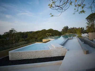 a swimming pool with a stone wall around it at Lux apartment 100 sqm in Laguna in Bang Tao Beach