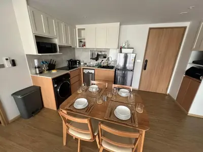 a kitchen with a wooden table with chairs and a dining room at Lux apartment 100 sqm in Laguna in Bang Tao Beach