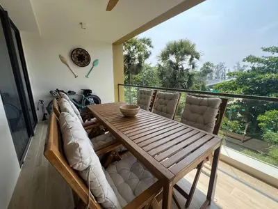 a dining room with a table and chairs on a balcony at Lux apartment 100 sqm in Laguna in Bang Tao Beach