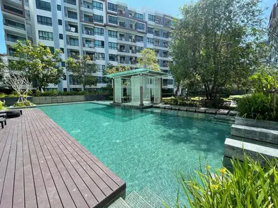 a large swimming pool in front of a building at 1 Bedroom Condos Close to Shopping Malls in Ban Rangeng