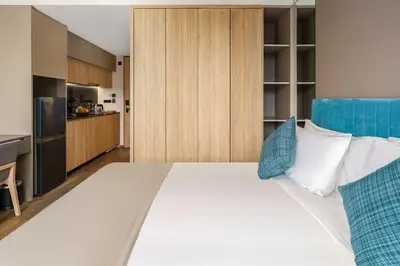 a bedroom with a large white bed with blue pillows at Amazing La Green 10 min walk to Layan Beach in Layan Beach