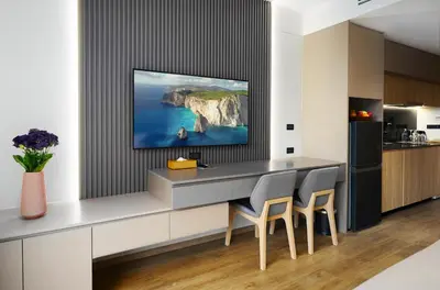 a kitchen with a counter with a tv on a wall at Amazing La Green 10 min walk to Layan Beach in Layan Beach