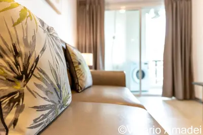 a couch in a living room with a flower pattern at OMNIAPHUKET - Pool View Apartment at Phuket Villa Patong Beach in Patong Beach