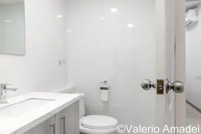 a white bathroom with a toilet and a sink at OMNIAPHUKET - Pool View Apartment at Phuket Villa Patong Beach in Patong Beach