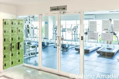 a gym with sliding glass doors and machines at OMNIAPHUKET - Pool View Apartment at Phuket Villa Patong Beach in Patong Beach