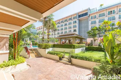 a courtyard in a hotel with a building at OMNIAPHUKET - Pool View Apartment at Phuket Villa Patong Beach in Patong Beach