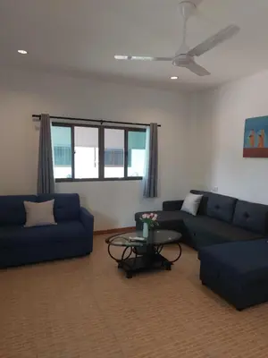 a living room with two blue couches and a table at Smile House Apartment 24 in Karon Beach