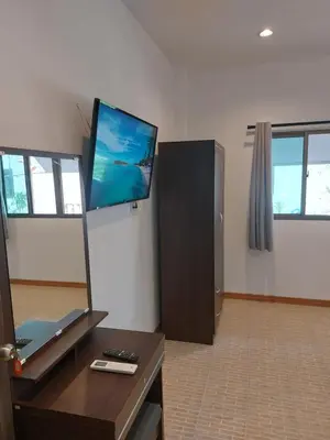 a living room with a flat screen tv on the wall at Smile House Apartment 24 in Karon Beach