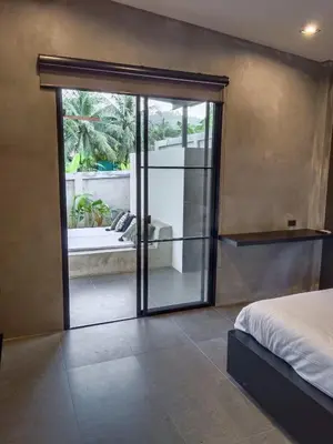 a bedroom with a sliding glass door to a patio at New 2 BR Villa Nai Thon in Nai Yang Beach