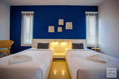 two beds in a room with a blue wall at Chill House at Naiyang in Nai Yang Beach