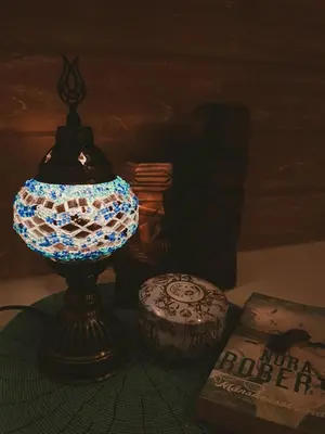 a lamp sitting on a table next to a book at Chill House at Naiyang in Nai Yang Beach