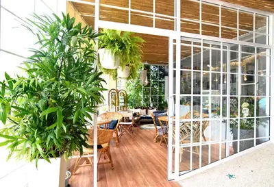 a dining room with a table and some plants at Chill House at Naiyang in Nai Yang Beach