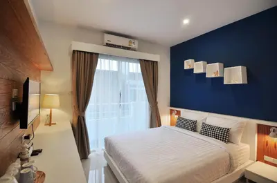 a bedroom with a bed and a blue wall at Chill House at Naiyang in Nai Yang Beach
