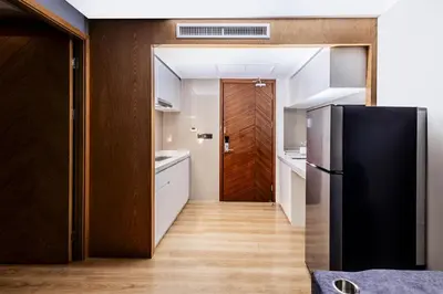 a kitchen with a black refrigerator and a hallway at Suite Edena 2BR Pool View 300m to Rawai in Rawai Beach