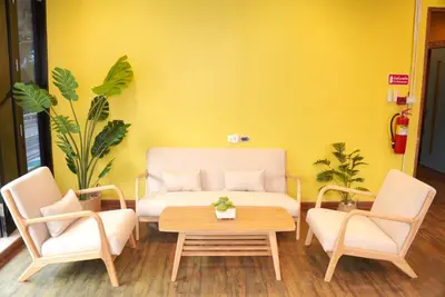 a living room with a couch and two chairs and a table at Bed & Beach Hostel Karon in Karon Beach