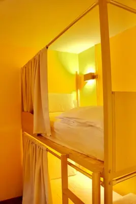 a bedroom with a bunk bed in a yellow room at Bed & Beach Hostel Karon in Karon Beach