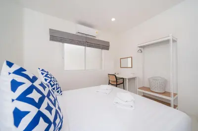 a white bedroom with a white bed and a window at 7BR Grand Pool Villa in heart Patong in Patong Beach