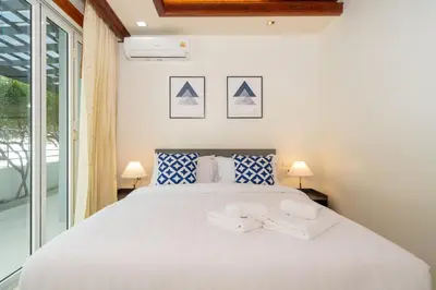 a bedroom with a white bed with two white towels on it at 7BR Grand Pool Villa in heart Patong in Patong Beach