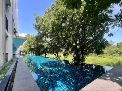 a swimming pool with blue tiles on the side of a building at Studio in Boat Avenue in Bang Tao Beach