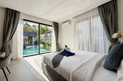 a bedroom with a large bed and a large window at Bougainvillea Luxury Pool Villas in Ban Pak Lak