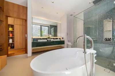 a bathroom with a tub and a glass shower at Bougainvillea Luxury Pool Villas in Ban Pak Lak