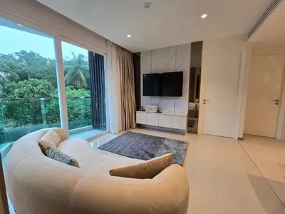 a living room with a white couch and a large window at Luxury Condo The City Phuket in Heart of Phuket in Kathu