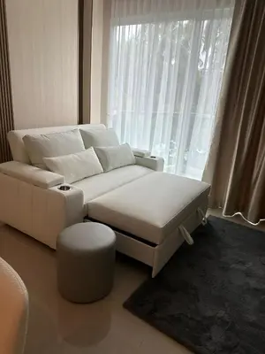 a white couch and stool in a room with a window at Luxury Condo The City Phuket in Heart of Phuket in Kathu