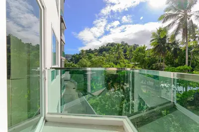 a glass balcony with a view of the jungle at Luxury Condo The City Phuket in Heart of Phuket in Kathu