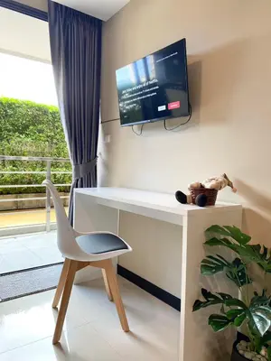 a room with a desk with a tv and a chair at Rawai Beach - 1 BR Cozy Condo in Nai Harn Beach