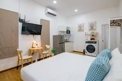 a bedroom with a bed and a table with chairs at Sachi Minimal House Bangtao Beach - Near Muay Thai Gym in Surin Beach