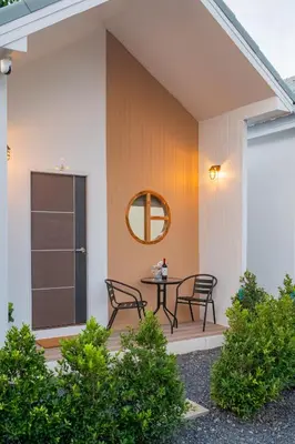 a patio with chairs and a table on a house at Sachi Minimal House Bangtao Beach - Near Muay Thai Gym in Surin Beach