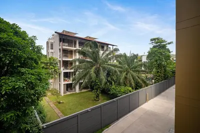 a balcony view of a building with palm trees at Laguna Beachside Block 3 by Banyan Living in Ban Thalat Choeng Thale