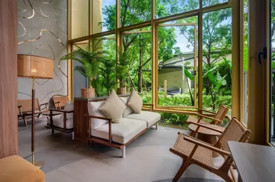 a living room with a couch and a large window at Laguna Beachside Block 3 by Banyan Living in Ban Thalat Choeng Thale