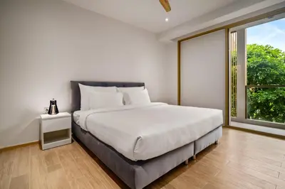 a bedroom with a bed and a large window at Laguna Beachside Block 3 by Banyan Living in Ban Thalat Choeng Thale