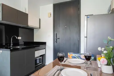 a kitchen with a table with two glasses of wine at \u82ad\u4e1cTheDeck199\u7cbe\u88c5\u4e00\u5367\u5ba4\u516c\u5bd3 \u8fd1\u82ad\u4e1c\u6d77\u6ee9Bangla\u6c5f\u897f\u51b7 in Patong Beach