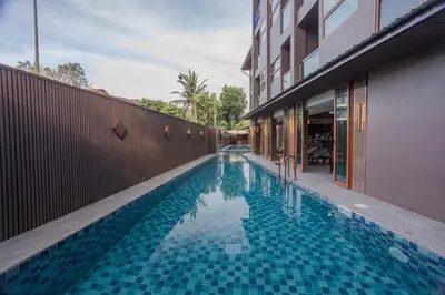 a swimming pool next to a building at Syama V Beachfront Resort Ao Nang Krabi, Aspira Collection - Adults Only in Ao Nang Beach