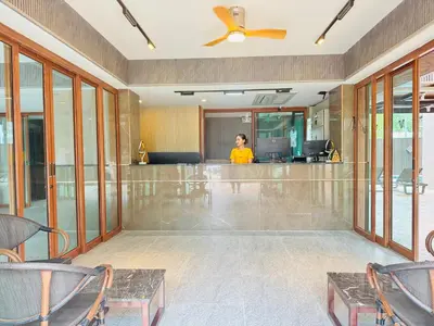 a woman is standing in a lobby with a bar at Syama V Beachfront Resort Ao Nang Krabi, Aspira Collection - Adults Only in Ao Nang Beach