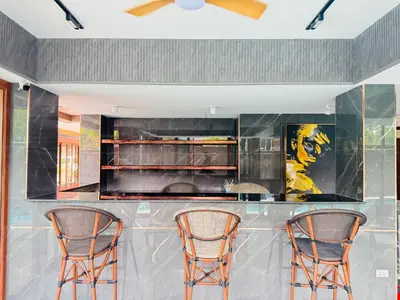 a kitchen with two chairs at a bar at Syama V Beachfront Resort Ao Nang Krabi, Aspira Collection - Adults Only in Ao Nang Beach