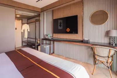 a hotel room with a bed and a television at Syama V Beachfront Resort Ao Nang Krabi, Aspira Collection - Adults Only in Ao Nang Beach