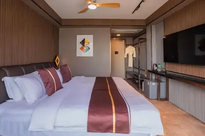 a bedroom with a large bed and a flat screen tv at Syama V Beachfront Resort Ao Nang Krabi, Aspira Collection - Adults Only in Ao Nang Beach