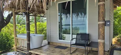 a porch with a tub and a chair on a deck at Krabi Sea View Orchid Beach room in Krabi town