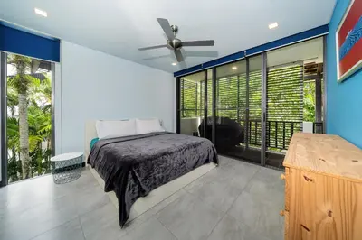 a bedroom with a bed and a large window at Bangtao Beach Garden - 2 BR Apartment in Surin Beach