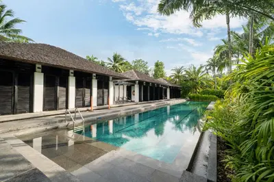a swimming pool in front of a villa at Bangtao Beach Garden - 2 BR Apartment in Surin Beach
