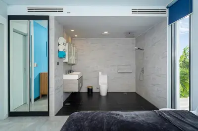 a bedroom with a bathroom with a shower and a sink at Bangtao Beach Garden - 2 BR Apartment in Surin Beach