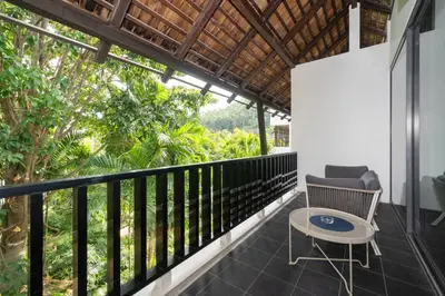 a balcony with a chair and a table at Bangtao Beach Garden - 2 BR Apartment in Surin Beach