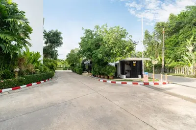 a road in a park with trees and a building at Bangtao Beach Garden - 2 BR Apartment in Surin Beach
